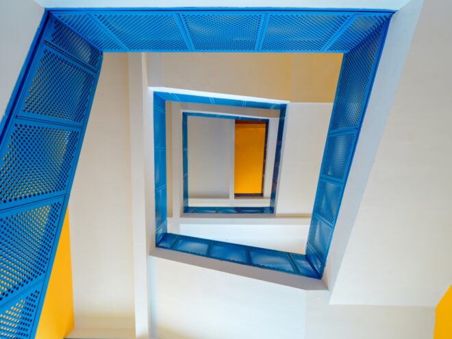 a shot of a spiral staircase with blue rails