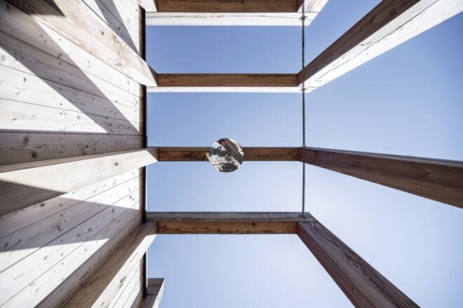 a view looking up at the timber lake house from the ground