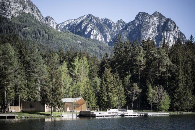 a lake with forest and mountains in the background and reflected in the lake