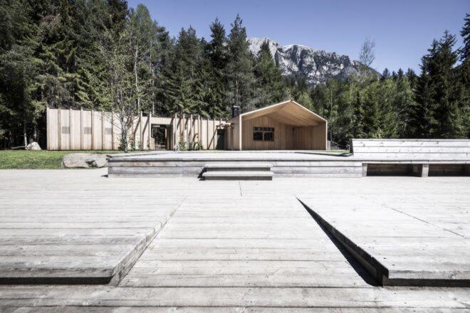 a wood dock in front of a lake house
