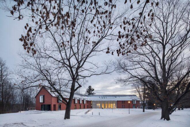 V-shaped, gabled brick building in snowy landscape