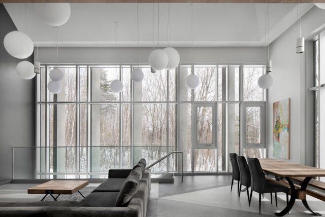 gray sofa beside wall of glass revealing a snowy landscape