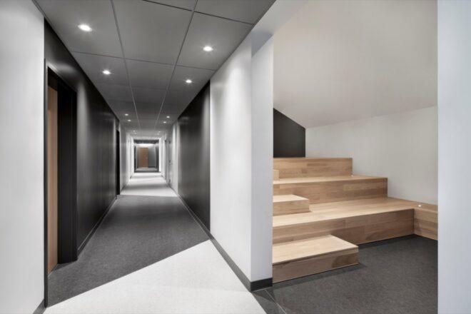 gray hallway with wooden stairs