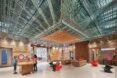tan sofas and spinning chairs in a museum room with a metal ceiling