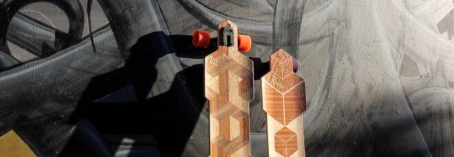 two wooden skateboards up against a grey and black wall