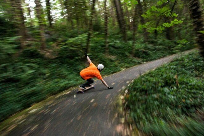 man riding a skateboard around a tight curve