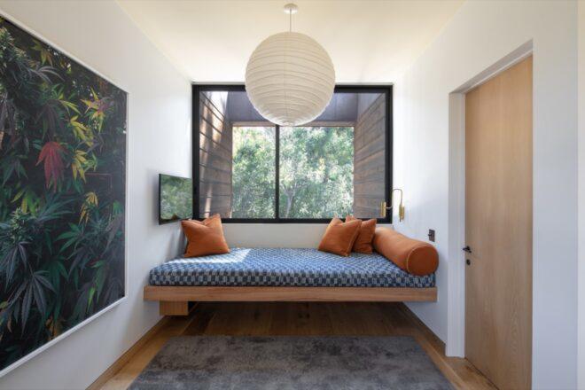 a white-walled room with a bench built into the wall by a window