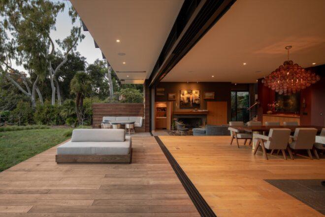 an indoor/outdoor area with wood floors and lounge furniture