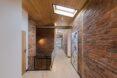 upper floor hallway featuring light-colored wood accents and exposed brick. a skylight illuminates the hall