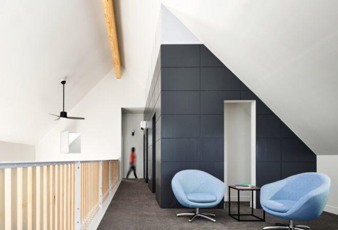 two blue lounge chairs on a lofted area