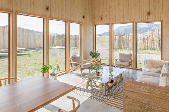 wood dining table next to white sofa and chairs around a glass coffee table