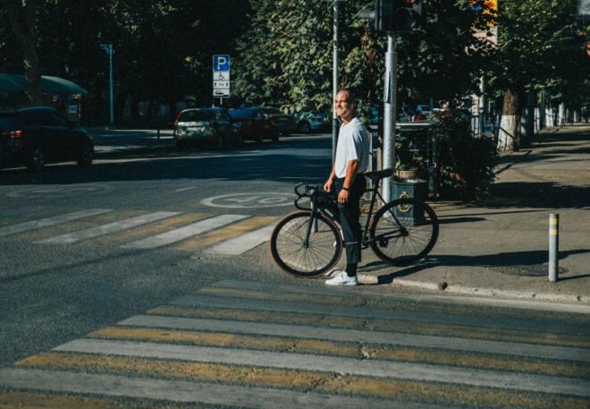 a street corner where a man stands with a bike