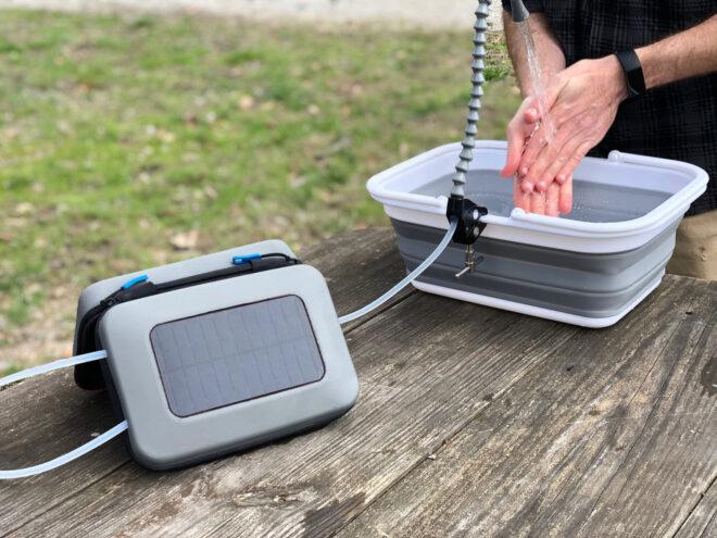 solar panel set up on table and connected to small hand washing station