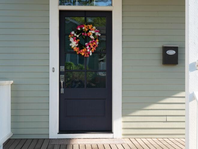 front door decorated with a tulip wreath