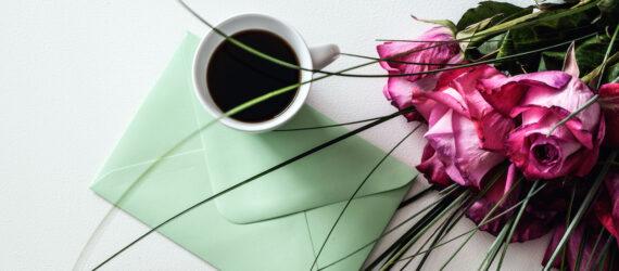 green envelope, coffee and pink roses