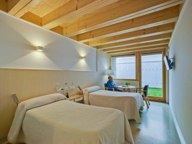 person sitting at table in a room with two large beds