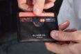 person pulling card out of vegan leather cardholder