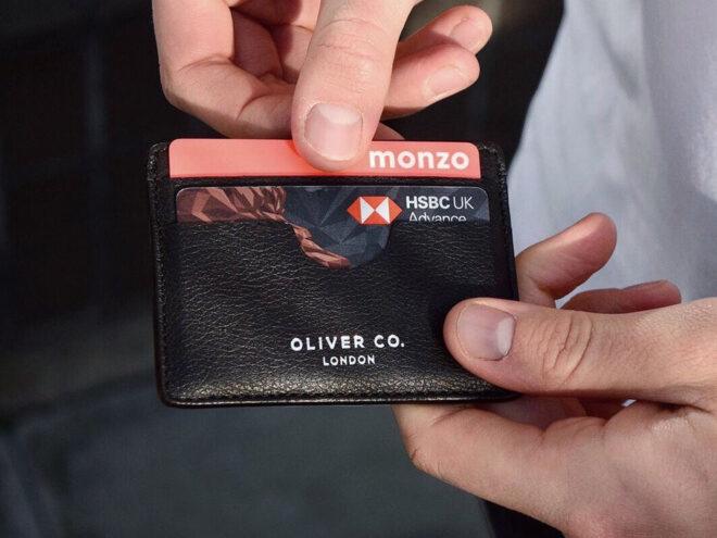 person pulling card out of vegan leather cardholder