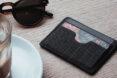vegan leather cardholder near cup of coffee and sunglasses