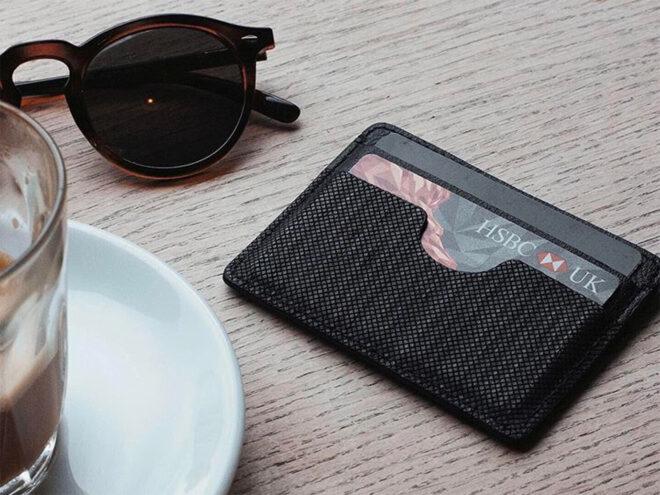 vegan leather cardholder near cup of coffee and sunglasses