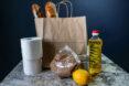 paper bag with loaves of bread, toilet paper, lemon and vegetable oil