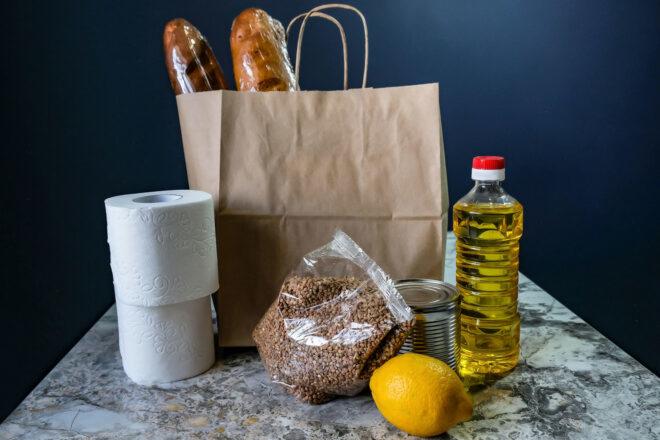 paper bag with loaves of bread, toilet paper, lemon and vegetable oil
