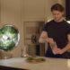 person grabbing fresh greens from a round indoor garden to add to a smoothie
