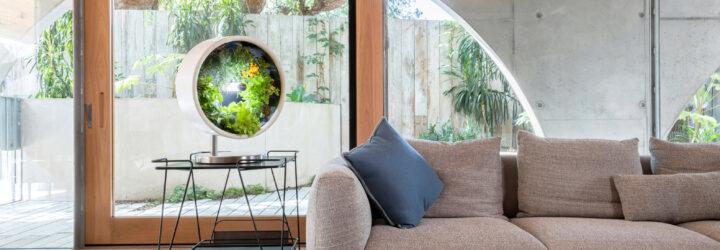 round indoor garden on an end table beside a gray sofa