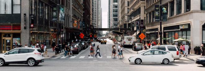a city street with cars and people passing by