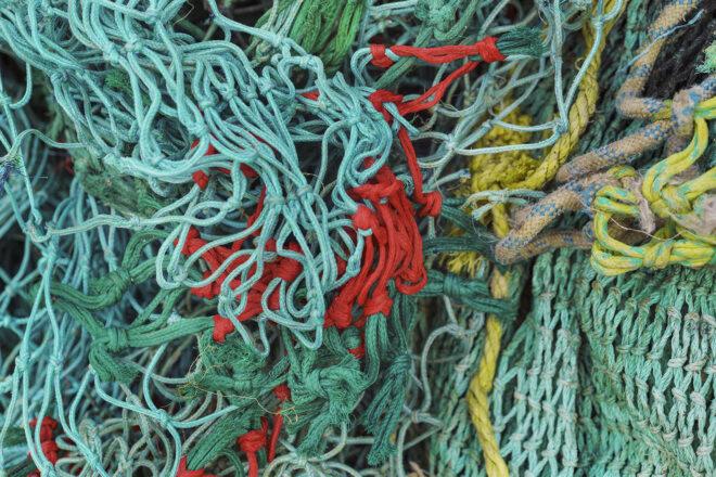 closeup of blue, teal, red and yellow colored fishing nets