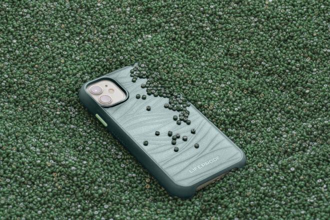 a phone in a teal phone case, surrounded by teal/green plastic parts