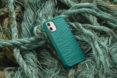 a phone in a teal case on a pile of old fishing nets and ropes