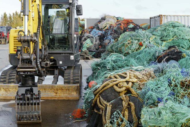 a tractor next to a pile of old fishing nets