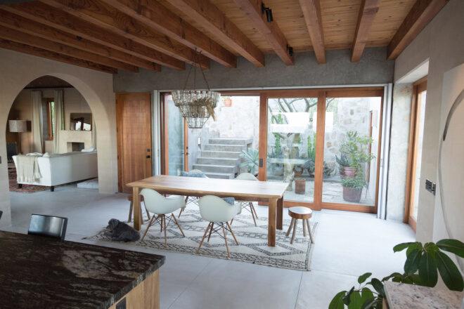a dining area with a dining table and chairs next to sliding glass doors