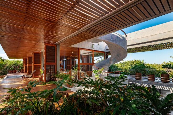 an open layout villa with a spiral staircase leading to upper floors