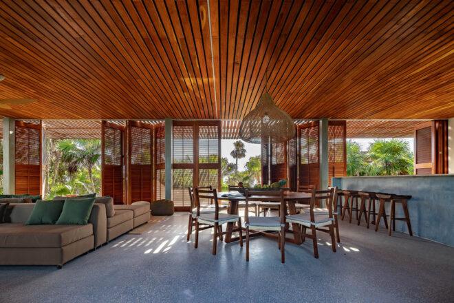 a dining area with chairs around a table, in a building with wood ceilings and accents