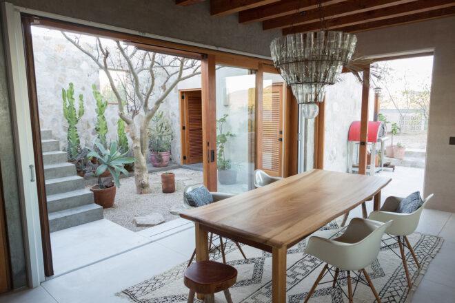 another angle of a dining area with a dining table and chairs next to sliding glass doors