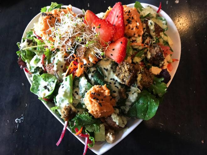 a falafel salad in a heart-shaped bowl