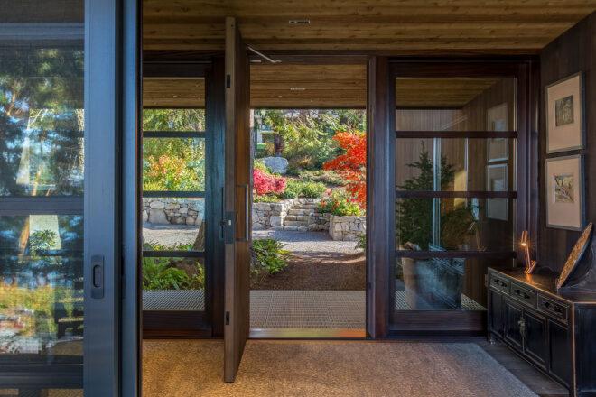 the inside of a home with open doors looking out on a garden