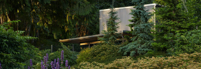 a home tucked into a green landscape, with purple flowers to the left