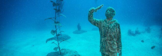 underwater statue of child holding a fish