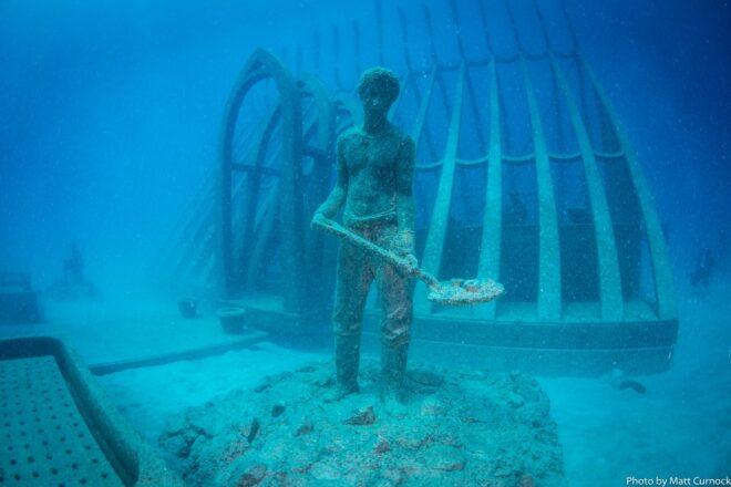 statue of person with shovel underwater