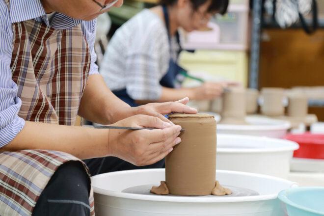 person making a vase on a pottery wheel