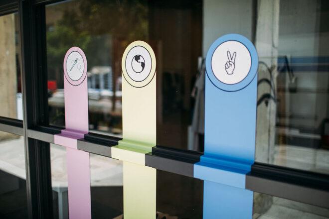three labels: one with a needle and thread, one with the world, and one with a peace sign