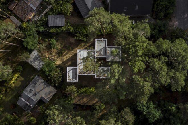 aerial view of home with multiple cube volumes in a forest