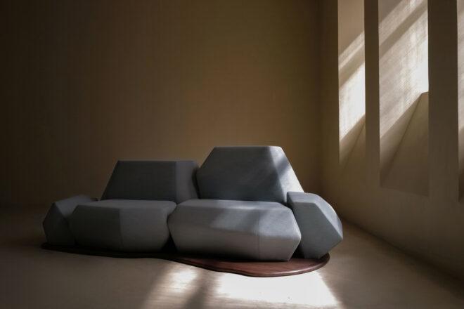 geometric light blue sofa with a curvy wooden base in a beige room