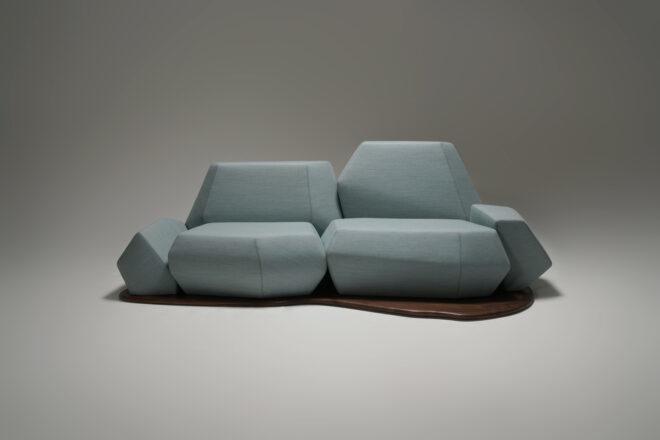 geometric light blue sofa with a curvy wooden base on a white background