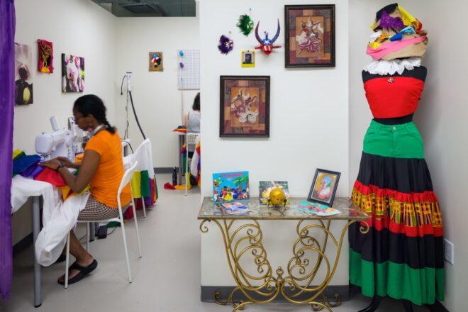 person using a sewing machine in a room covered in art
