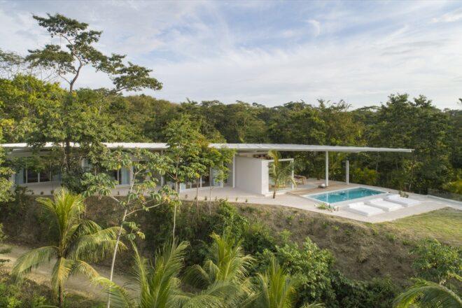 a far shot of the home, showcasing the greenery surrounding the villa