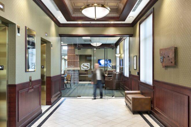 person walking in a bank with brown and beige decor